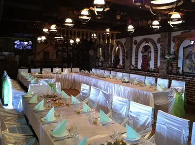 a row of tables in a room with white chairs at Шапкова Къща in Delchevo