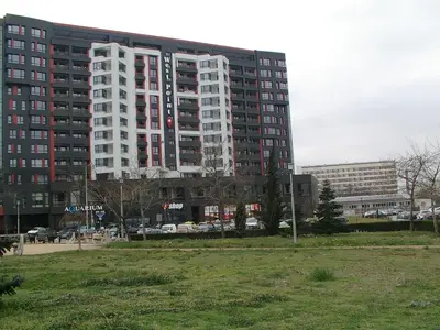 a tall building with a field in front of it at Apartment KALINA with free private parking in Plovdiv