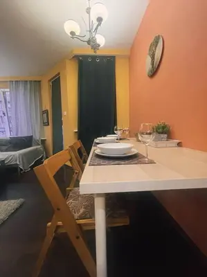 a dining room with a table with a plate and wine glass at A Colorful Apart for a Start in Sofia