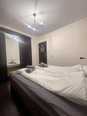 a bedroom with a large white bed with a ceiling at A Colorful Apart for a Start in Sofia