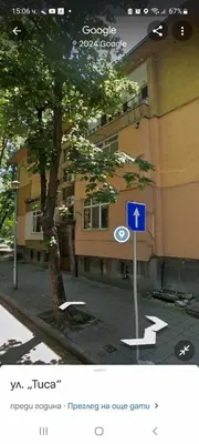 a street sign in front of a building with a tree at Zoev in Plovdiv