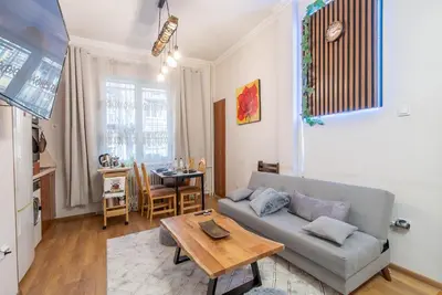 a living room with a couch and a table at Two Homelike Apartments by NDK and Vitosha Blvd with 2 Free Parking Spots in Sofia
