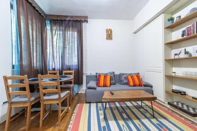 a living room with a couch and a table and chairs at Two Homelike Apartments by NDK and Vitosha Blvd with 2 Free Parking Spots in Sofia