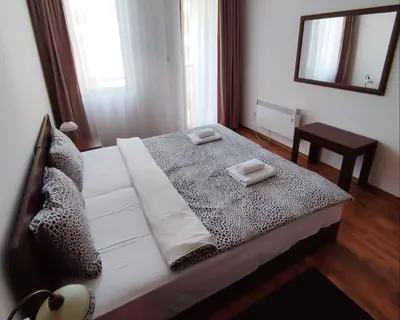 a bedroom with a large white bed with a mirror at 
