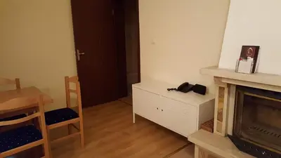 a living room with a fireplace and a table and a chair at The Castle Complex - Apartment 401 in Pamporovo
