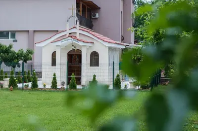 a building with a church in front of a yard at Complex Baroto in Gotse Delchev