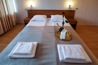 a bedroom with two beds with white towels and a table at Complex Baroto in Gotse Delchev