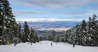 a group of people skiing down a snow covered slope at apartment Mountain Delight, Bansko in Bansko