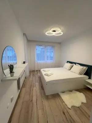a white bedroom with a bed and a mirror at MidnightBlue Apartment in Bansko