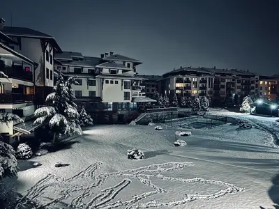 a snow covered city with buildings in the background at MidnightBlue Apartment in Bansko