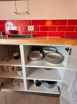a shelf with plates and pans in a kitchen at Cozy 1 bedroom apartment next to the gondola in Bansko