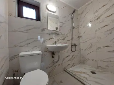 a white bathroom with a toilet and a sink at Стаи за гости Симона in Koprivshtitsa