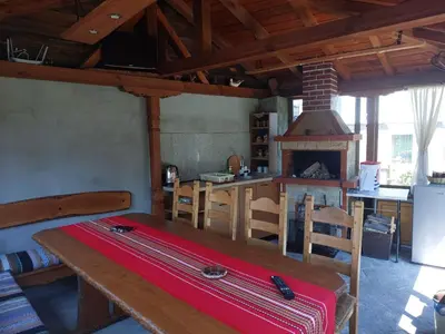 a room with a table and a kitchen with a stove at Стаи за гости Симона in Koprivshtitsa