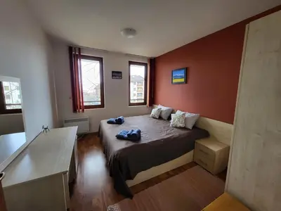 a bedroom with a large bed with red walls at Gri's place in Bansko