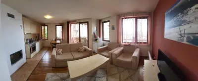 a living room with a couch and chairs and a tv at Gri's place in Bansko