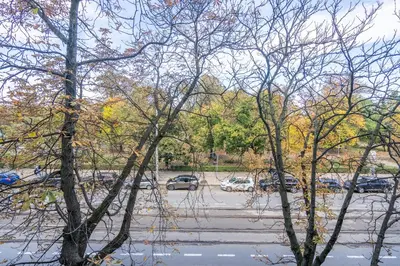 a parking lot with cars parked in a parking lot with trees at Opera in Sofia