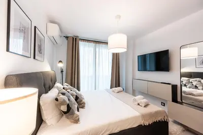 a bedroom with a large bed and a tv at Central View Apartment 1 in Blagoevgrad