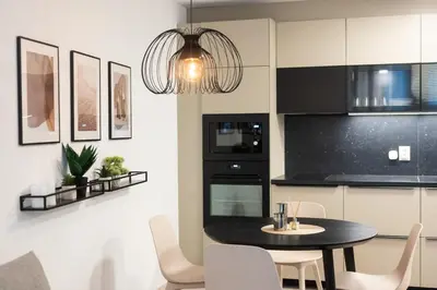 a kitchen with a black table and white chairs at Central View Apartment 1 in Blagoevgrad