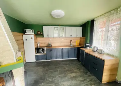 a kitchen with blue cabinets and a white refrigerator at Вила Маца in Sapareva Banya