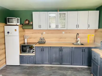 a kitchen with blue cabinets and a white refrigerator at Вила Маца in Sapareva Banya