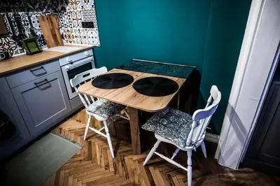 a kitchen with a wooden table and chairs at Green Flat Sofia Historic Center in Sofia