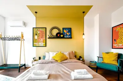 a bedroom with a large bed with yellow walls at 4 BDR 2 BTH Netflix Panorama Views in Sofia