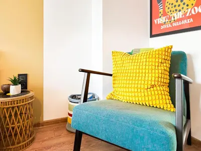 a blue chair with a yellow pillow in a room at 4 BDR 2 BTH Netflix Panorama Views in Sofia