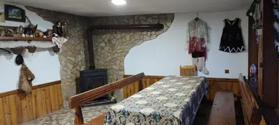 a room with a fireplace and a bed and a stone wall at Guest House Proynovi in Kalofer