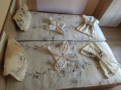 a bed with three sheets with bows on it at Guest House Proynovi in Kalofer