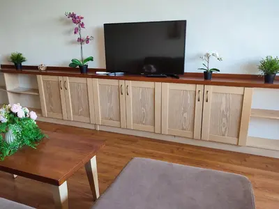 a living room with a flat screen tv and a table at Belvedere Holiday Club К505 Sunset View in Bansko
