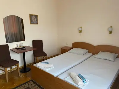 a bedroom with two beds and a table and chairs at Family Hotel 