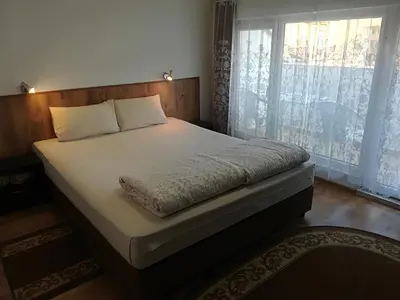 a bed in a bedroom with a large window at Family Hotel 