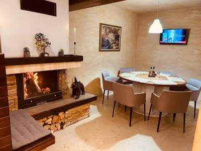 a dining room with a fireplace and a table and chairs at Villa Ema in Panichishte