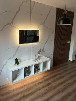 a white table in a room with a tv on a wall at Apartament G&M in Sandanski