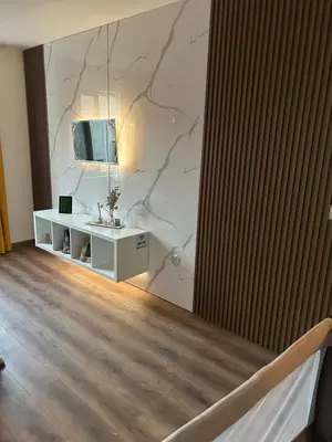 a room with a marble wall with a tv on it at Apartament G&M in Sandanski