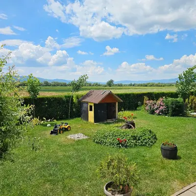 a small house in the middle of a yard at Guest House Belchin View in Belchin