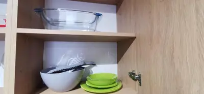 a kitchen cabinet with a mixing bowl and plates at Sunflower in Sofia
