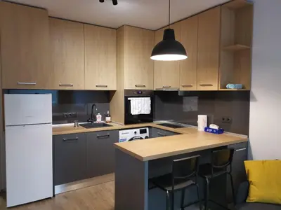 a kitchen with wooden cabinets and a white refrigerator at Sunflower in Sofia