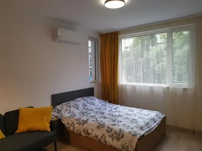 a bedroom with a bed and a window and a chair at Sunflower in Sofia