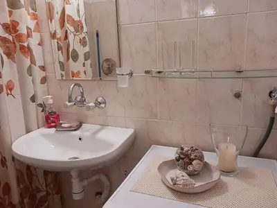 a bathroom with a sink and a toilet and a candle at Тристаен апартамент in Sofia