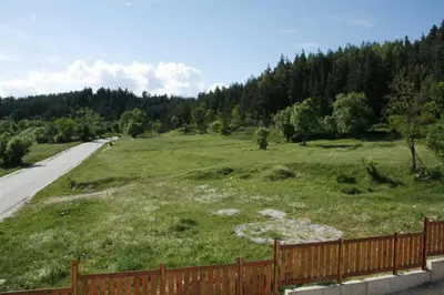 a field with a fence next to a road at Villa Detelina near the Bansko Ski Resort in Razlog