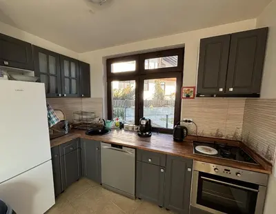 a kitchen with gray cabinets and a sink and a window at Villa Detelina near the Bansko Ski Resort in Razlog
