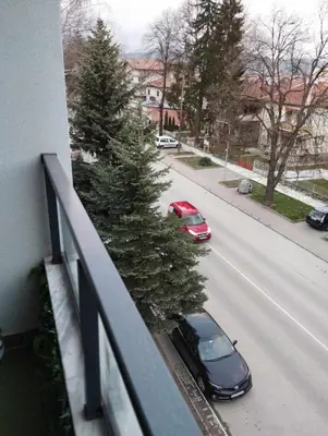 a car parked on a street with a christmas tree on a balcony at Апартамент за гости Боляри 2 in Velingrad