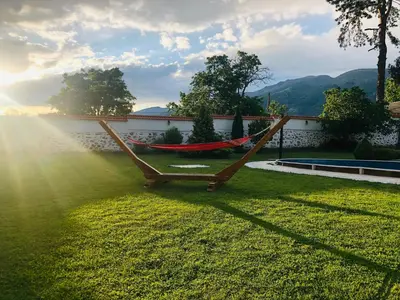 a hammock in a yard with the sun shining at Vila Teo in Vasil Levski