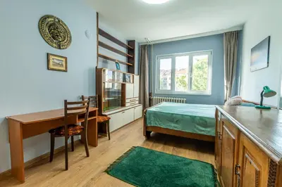 a bedroom with a bed and a desk and a table at 3-BR Central Residence in Sofia