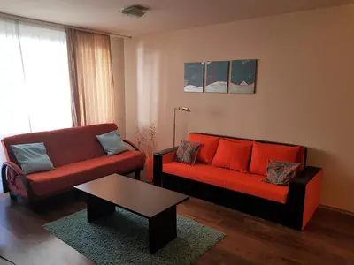 a living room with two red couches and a coffee table at Bansko Ski Apartments in Bansko Royal Towers in Bansko