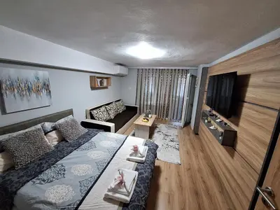 a bedroom with a bed and a living room with a couch at Apart 8 in Sandanski