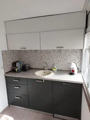 a kitchen counter with a sink and a mirror at Apart 8 in Sandanski