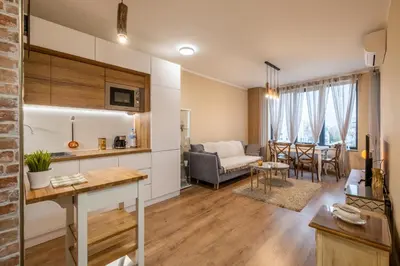 a kitchen and living room with a couch and a table at The Lemons Cozy Apartment in Sofia