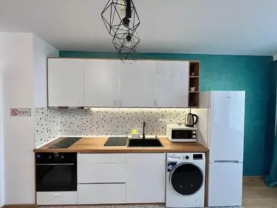 a kitchen with white cabinets and a sink and a microwave at Rio Apart Deluxe in Sofia